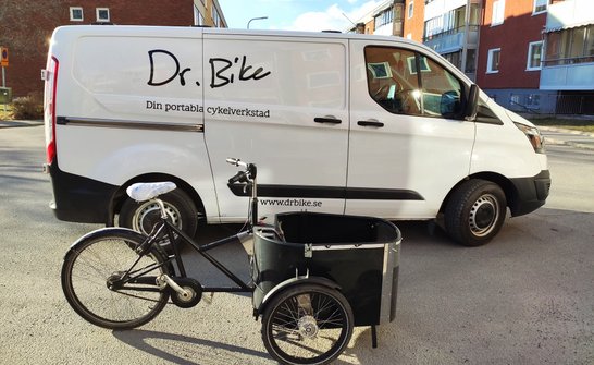 Vit van med Dr. Bike-logga i svart, det står även "din portabla cykelverkstad"